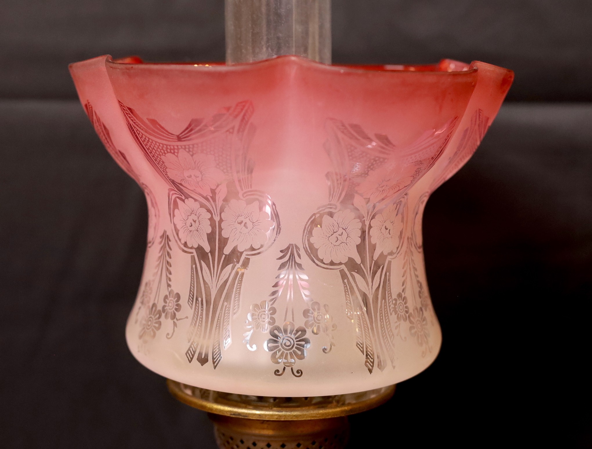 A late Victorian brass and pink opaque glass oil lamp with tinted frosted shade, height overall 56cm
